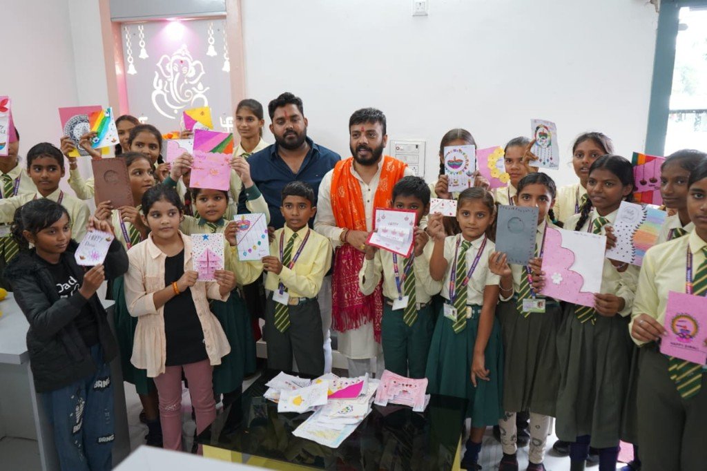 Students holding handmade Diwali cards with Dr. Dilip Pal